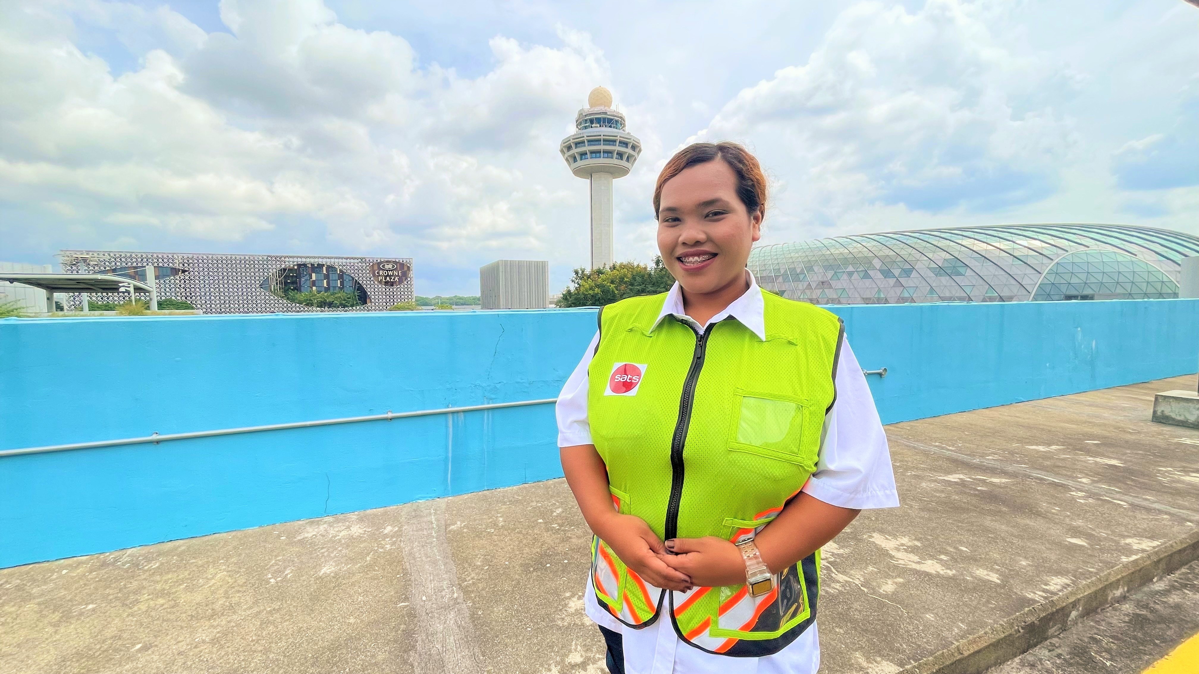 girl standing at changi airport with safety vest