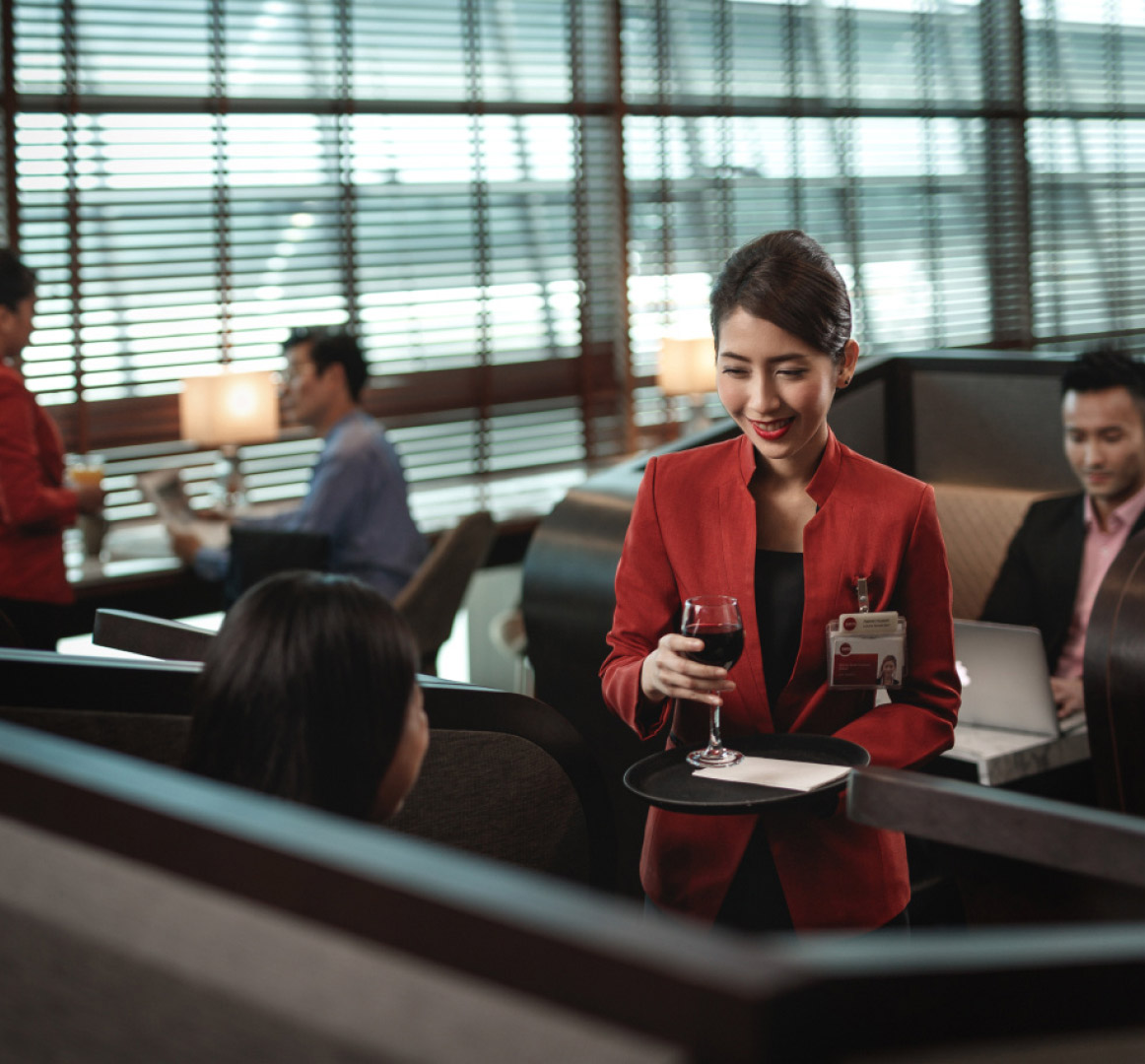 Customer service officer serving drinks to passenger at lounge 