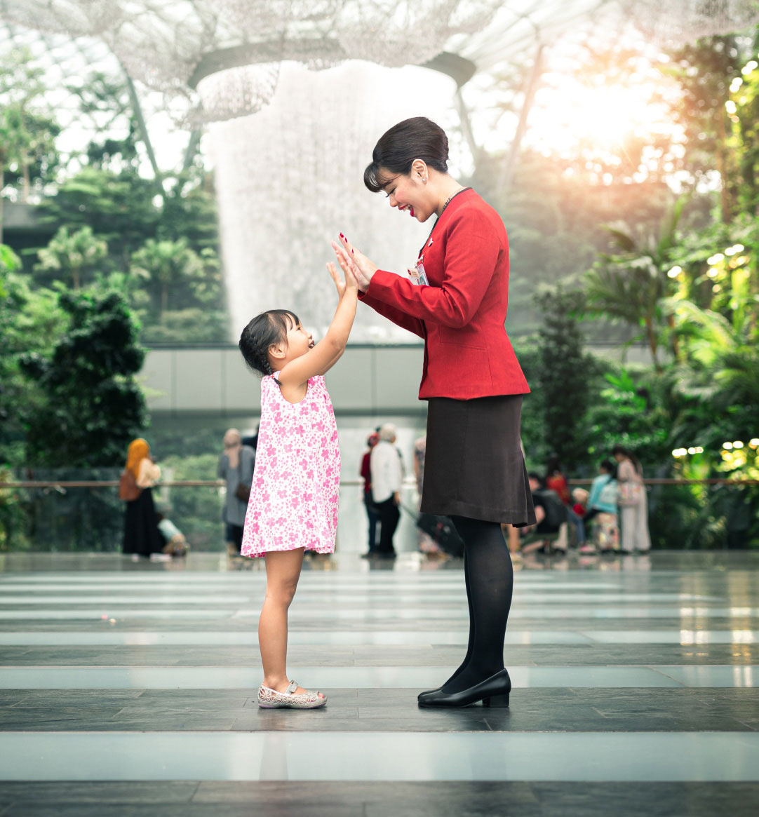 Girl hi-five with customer service officer at Jewel Changi