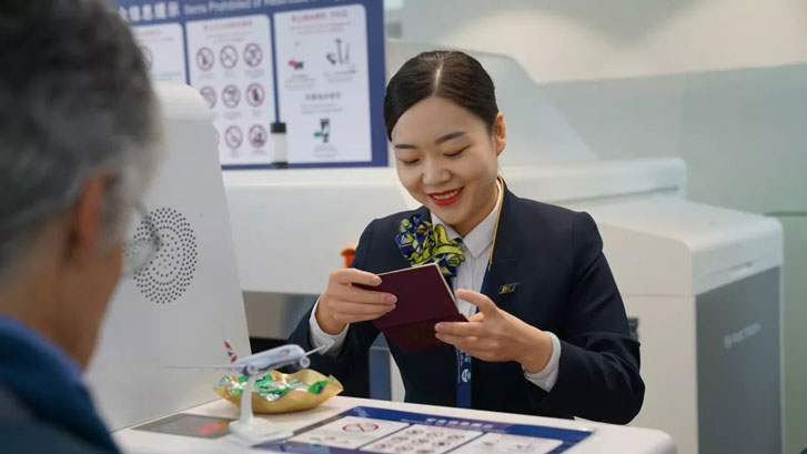 BCS Check-in staff checking passenger passport