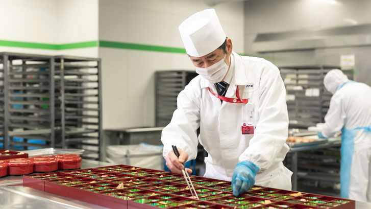 Japenese chef preparing bentos in a SATS TFK Narita Kitchen 1990