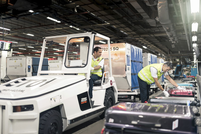 Man driving an electric tractor with baggage onboard